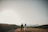 a bride and groom walking on a hill