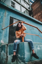woman hugging post of orange metal railings during day