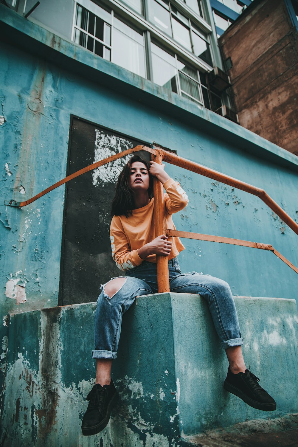 woman hugging post of orange metal railings during day