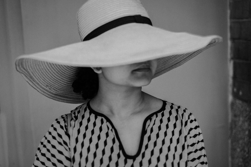 태양 모자를 쓰고 있는 여자의 회색조 사진