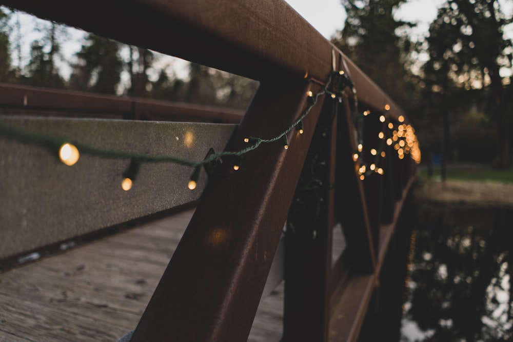 schwarze und orangefarbene Lichterketten an brauner Holzbrücke aufgehängt