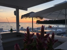 Outdoor hotel terrace featuring comfortable seating and views of a sunrise over the beach.