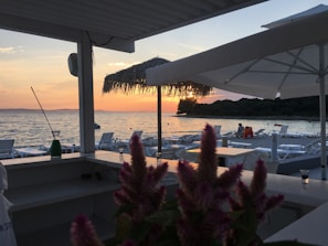 Sunset view from the hotel terrace with cozy seating and ocean breeze.