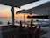 Sunset view over the calm sea with a cozy beach setup at Romalmare.