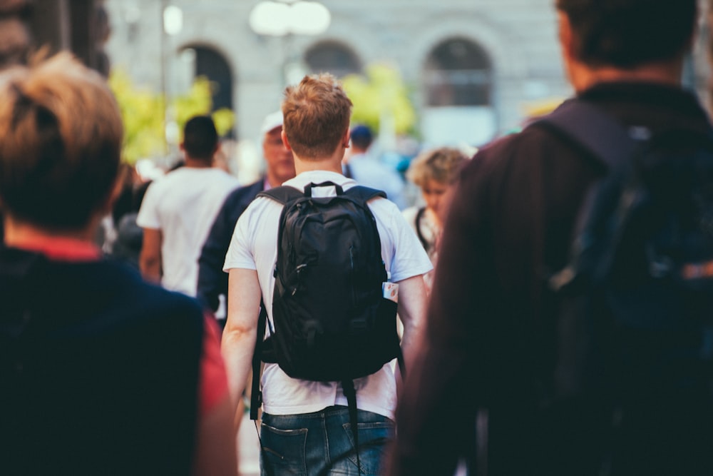 man in black and white shirt carrying black backpack