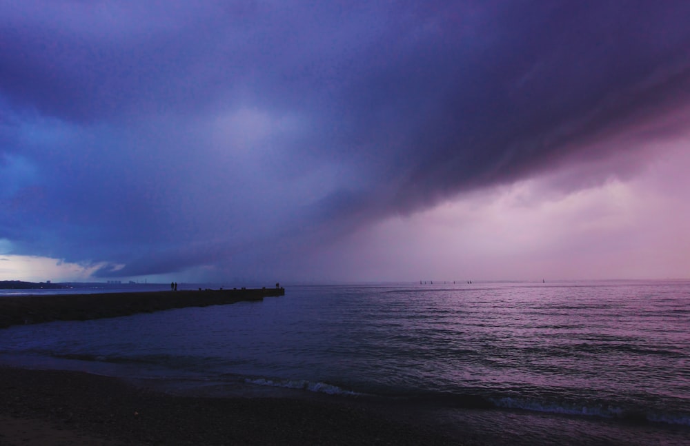 beach dock silhouette during cloudy day