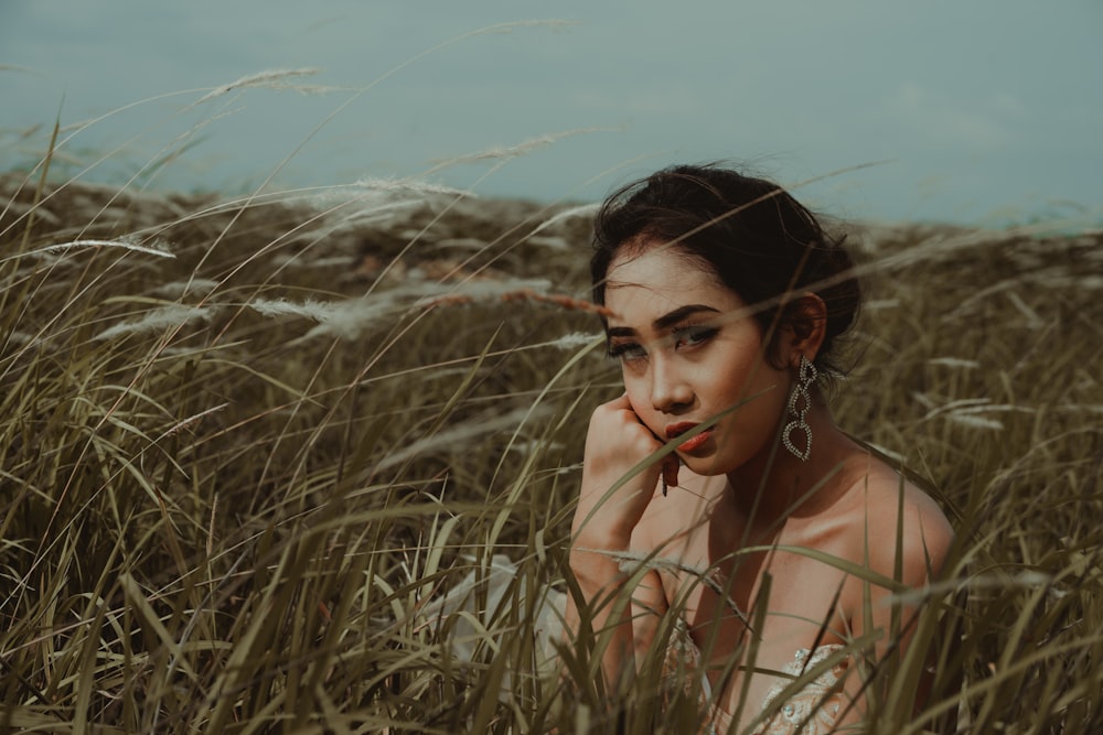 woman wearing brown top surrounded by grass during daytime