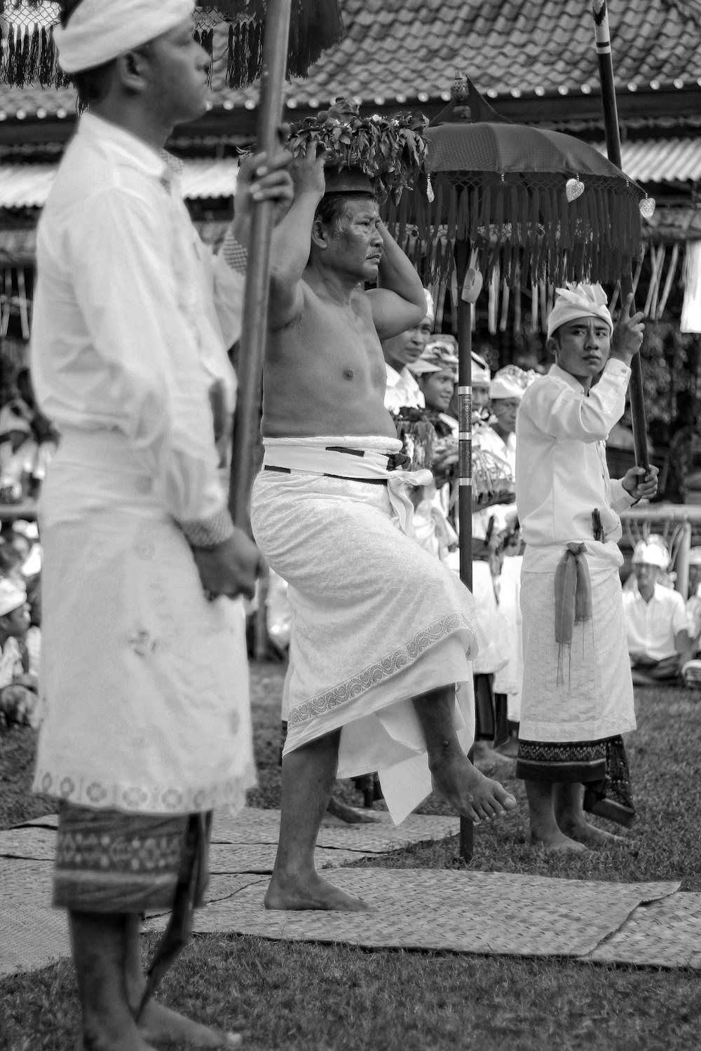 greyscale photography of men dancing near house