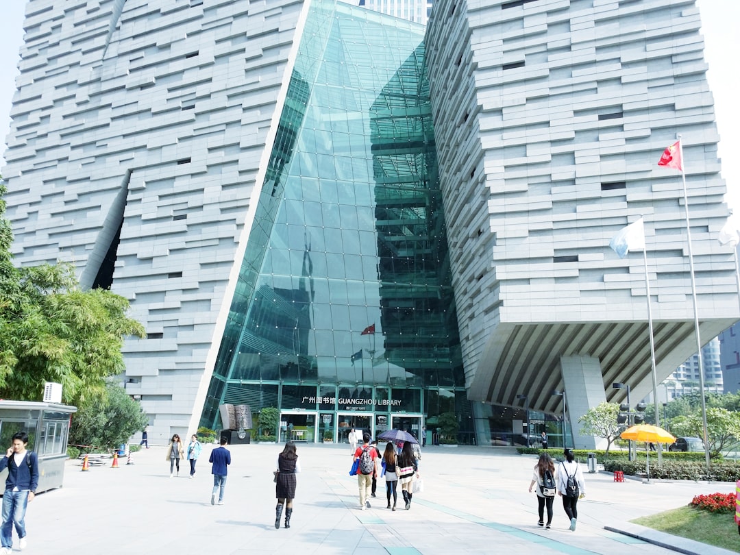 people walking towards grey building during daytime