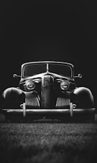 greyscale photo of classic vehicle on ground