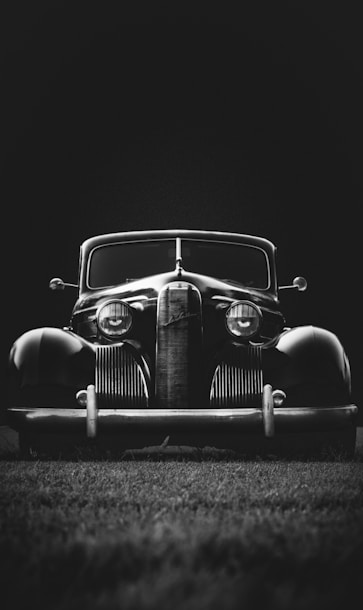 greyscale photo of classic vehicle on ground