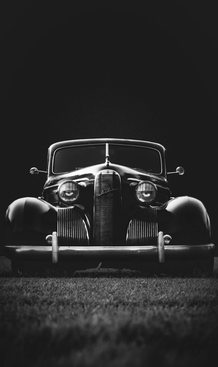 The chrome grille of a vintage car in black and white