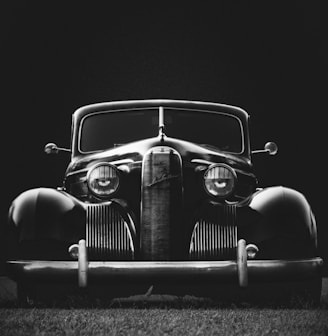 greyscale photo of classic vehicle on ground