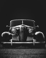 greyscale photo of classic vehicle on ground