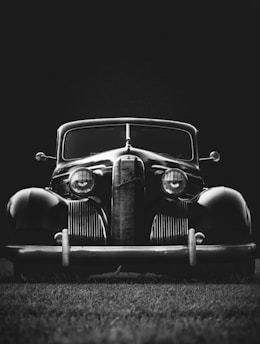 greyscale photo of classic vehicle on ground