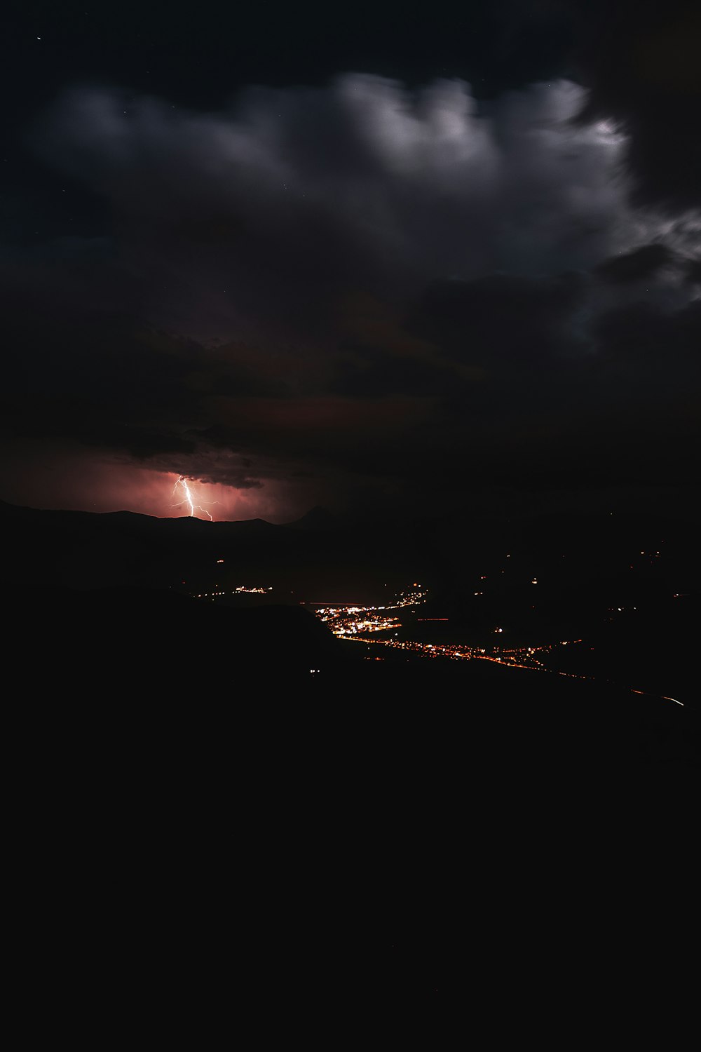 lighted building under thunder and gray clouds at nighttime