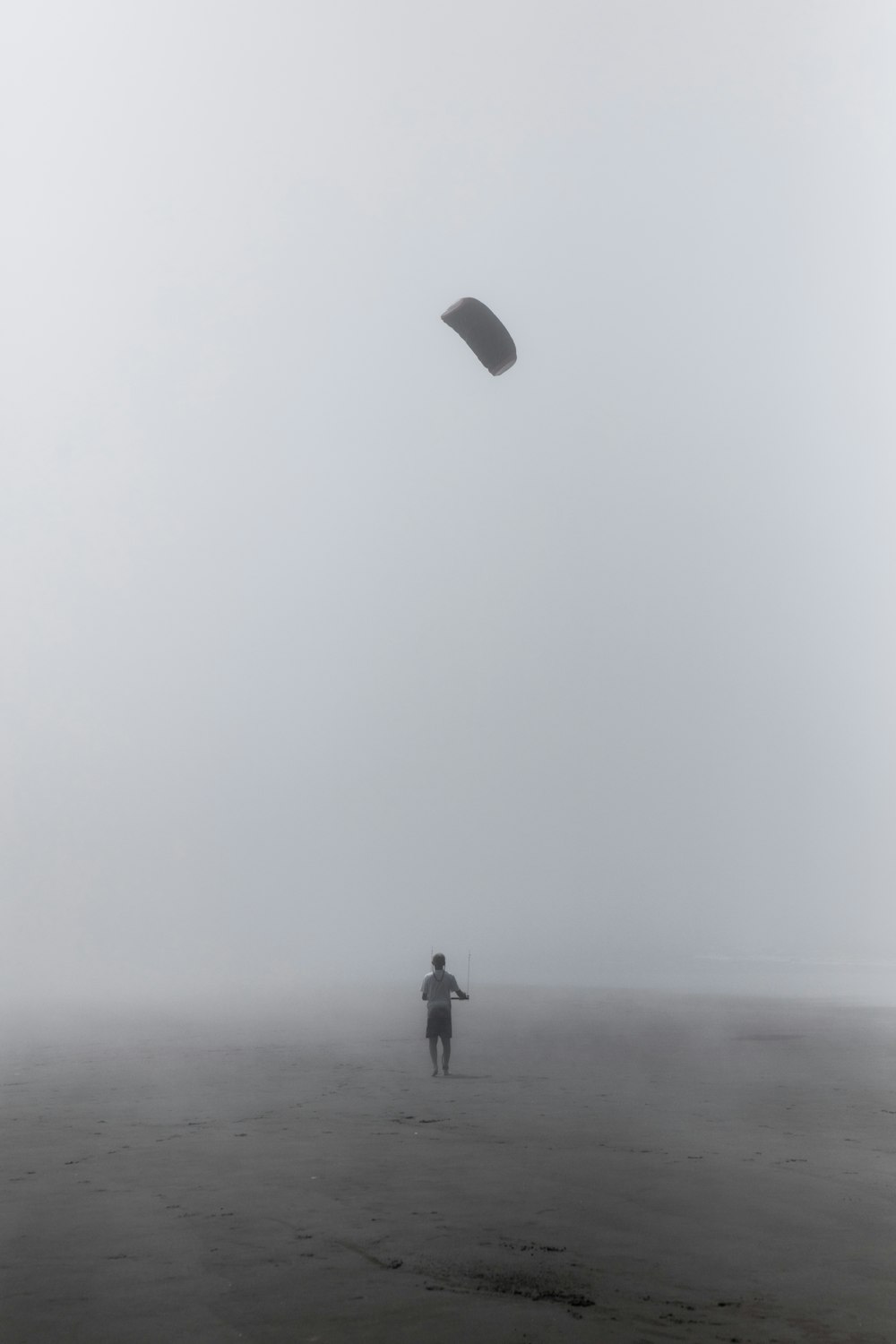 grayscale photography of person flying kite