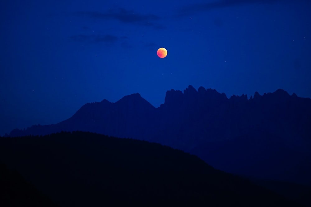 lunar eclipse with silhouette mountain