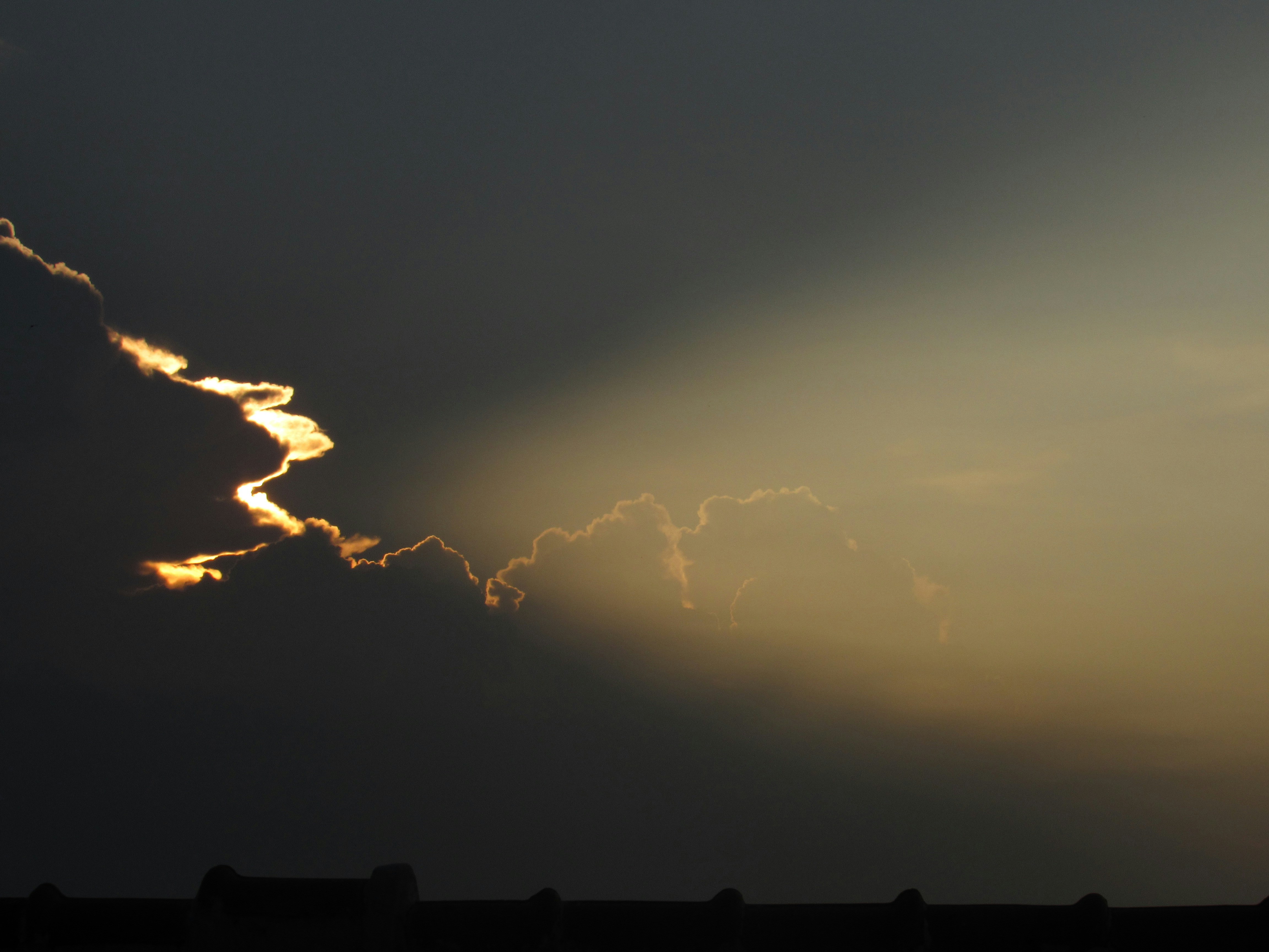 gray sky with rays piercing through clouds