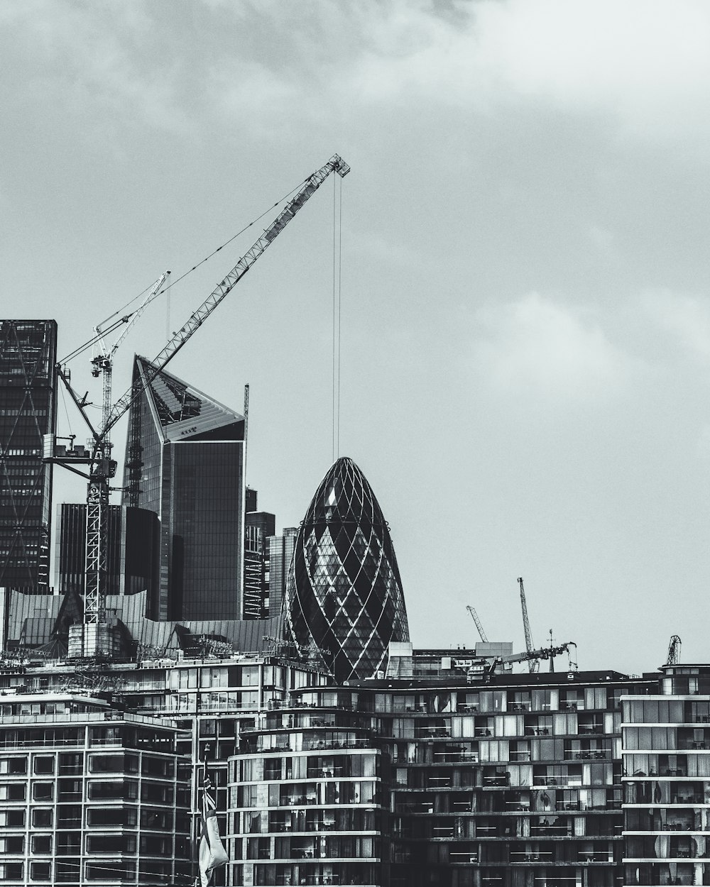 grayscale photography of 30 St.Mary Axe near on building