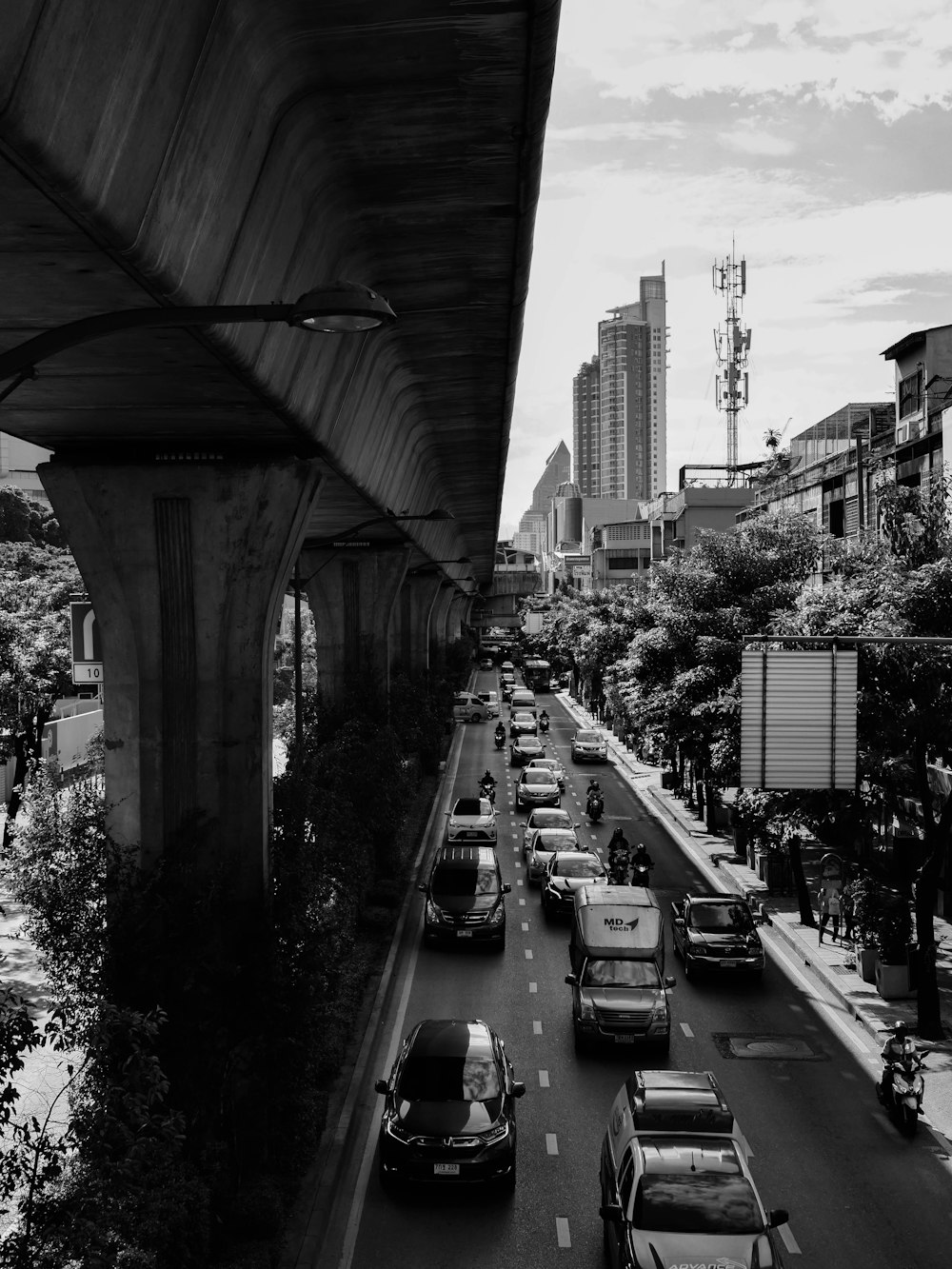 grayscale photography of vehicles passing by a busy road in the city