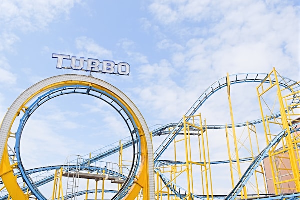 a yellow and blue roller-coaster with the word "turbo" spelled out over a 360 degree loop 