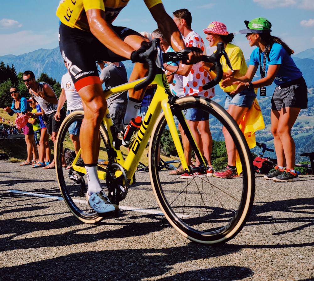 uomo in sella alla bicicletta gialla