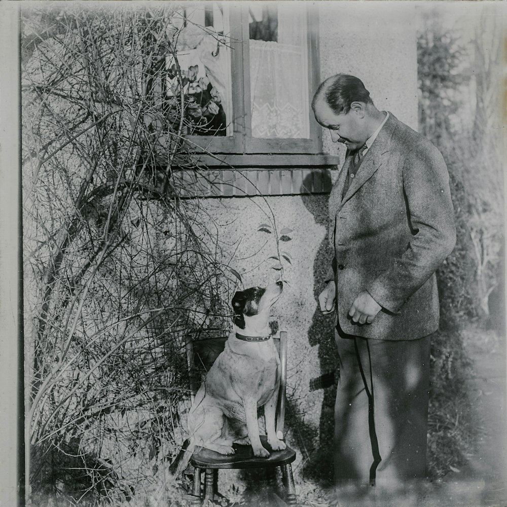 grayscale photo of man and dog