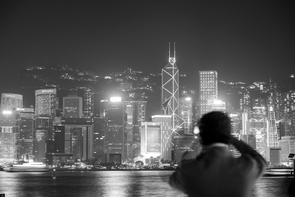 grayscale photography of person staring at city buildings