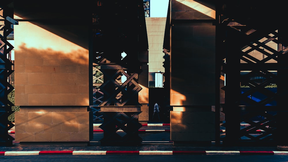 a person sitting on a bench under a bridge