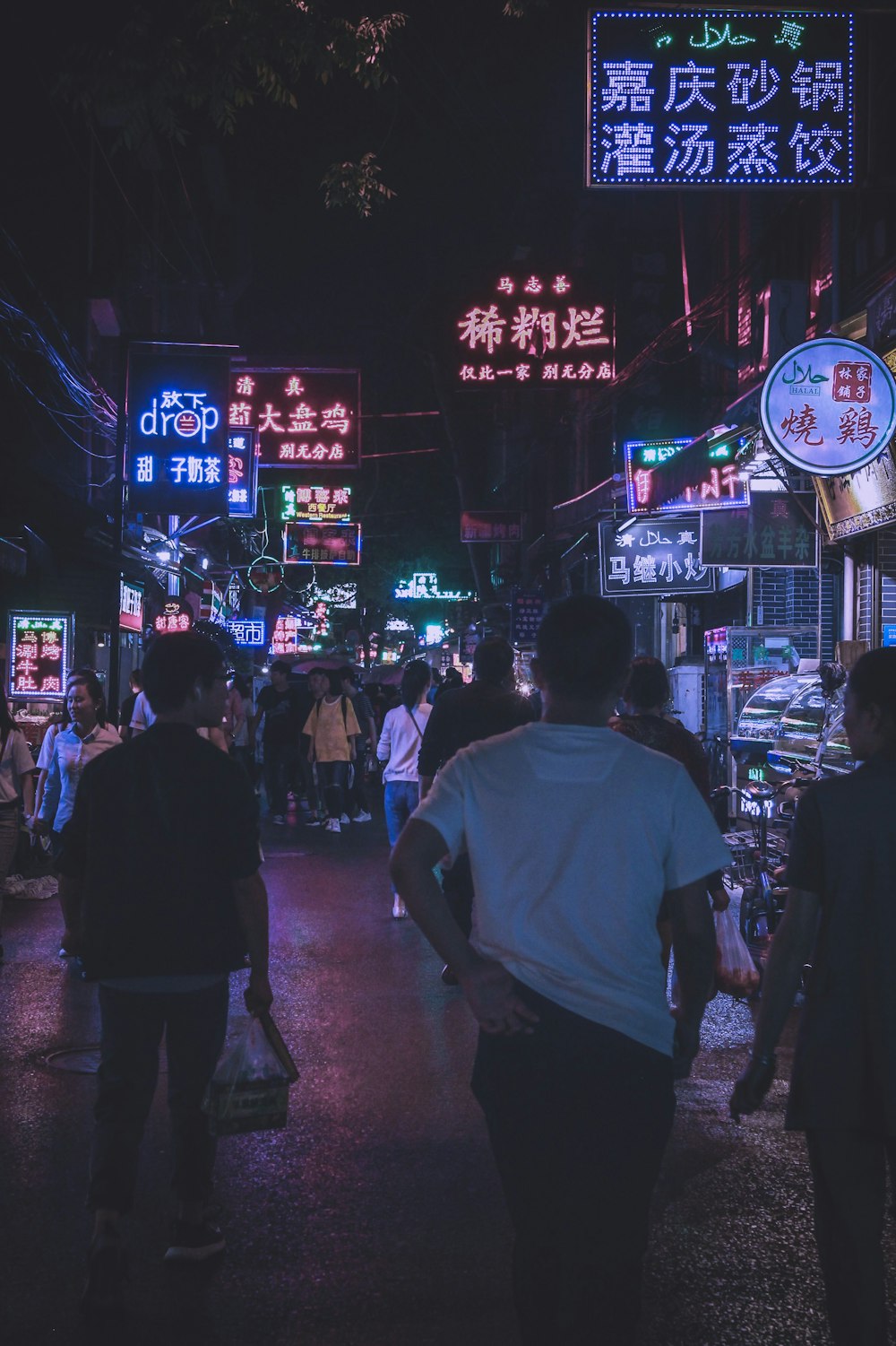 man wearing white shirt walking in the middle of street