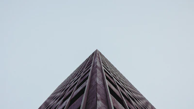 Wide-angle shot of a minimalist building surrounded by natural landscape, highlighting harmony between structure and environment.