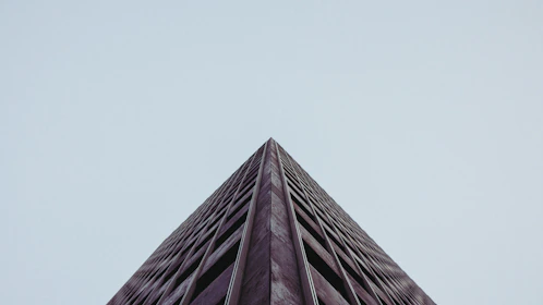 Wide-angle shot of a minimalist building surrounded by natural landscape, highlighting harmony between structure and environment.