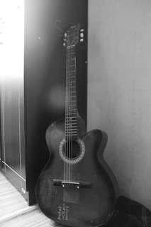 Vintage photo of Bill Wilson with his first guitar, capturing the start of his musical path