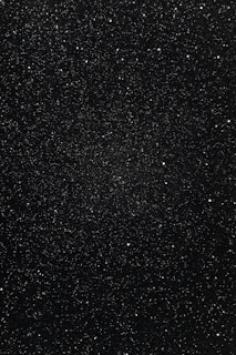 A vast expanse of space filled with countless small, bright stars scattered across a dark, seemingly infinite background.