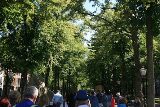 A group of students walking through the pharmacy college campus on a sunny day.