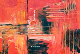 An abstract painting with bold, dynamic brushstrokes in warm tones. The composition features various intersecting lines and patches of color, primarily in shades of red, orange, and yellow. There are textured layers creating depth and visual interest, with some areas highlighted by streaks of white and black.
