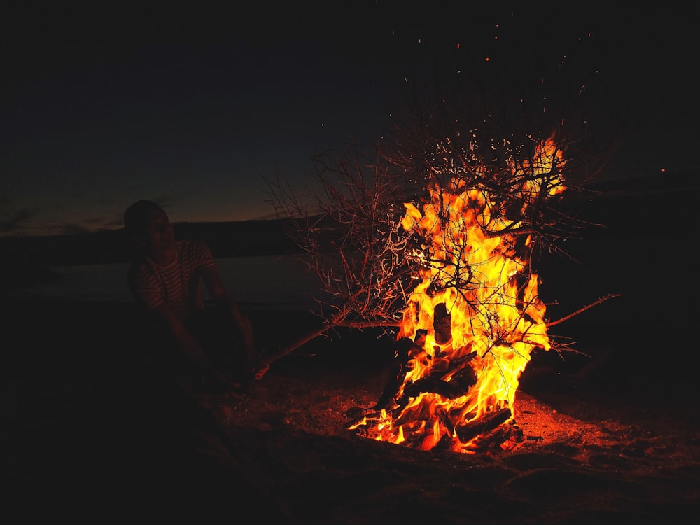 man in front of lighted bonfire