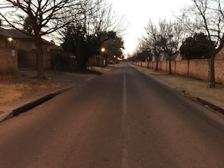 Evening shot of a quiet locality street lined with orange and white boundary walls.