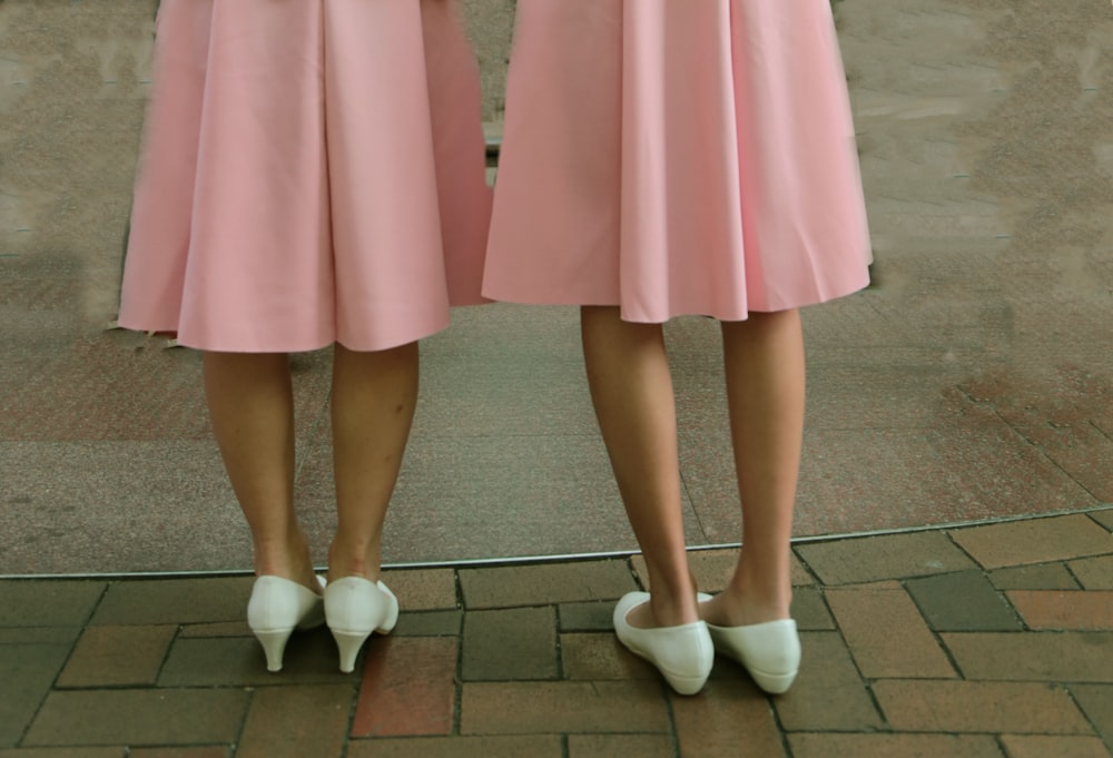 deux femmes portant des jupes roses