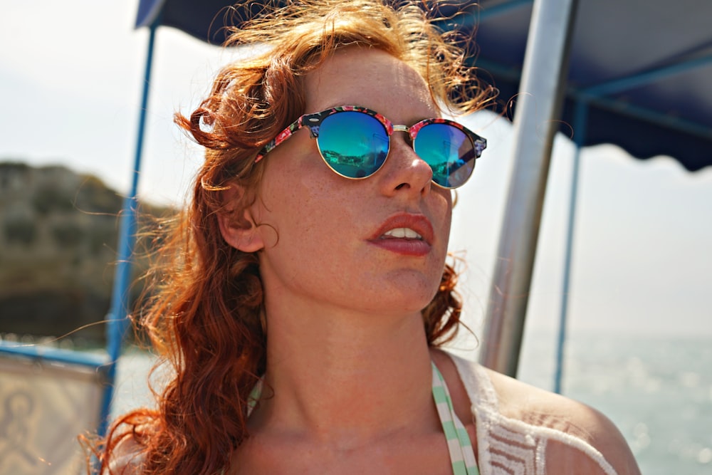selective focus photo of woman wearing sunglasses on seashore