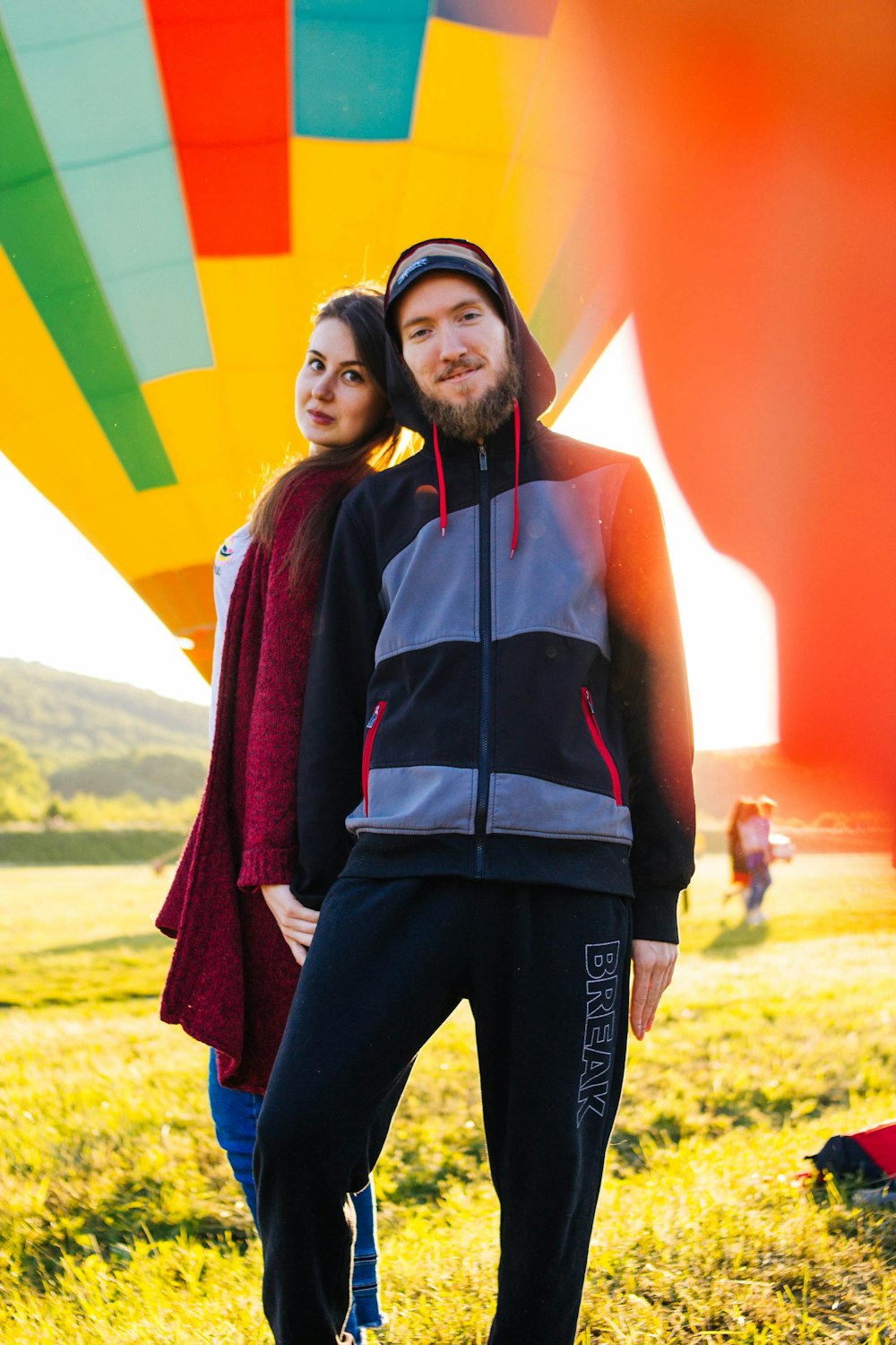 man and woman standing near hot air balloons