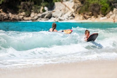 man and woman using body boards in body of water amazing google meet background