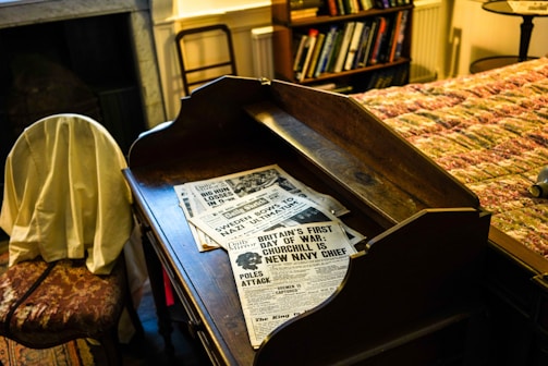 Stacks of dental journals and association newsletters on a wooden desk.