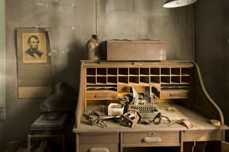 Dark, moody workspace with leather gear and a vintage typewriter on a steel desk.