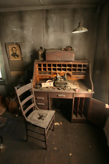 A dimly lit room with a vintage typewriter and scattered papers revealing secret documents.