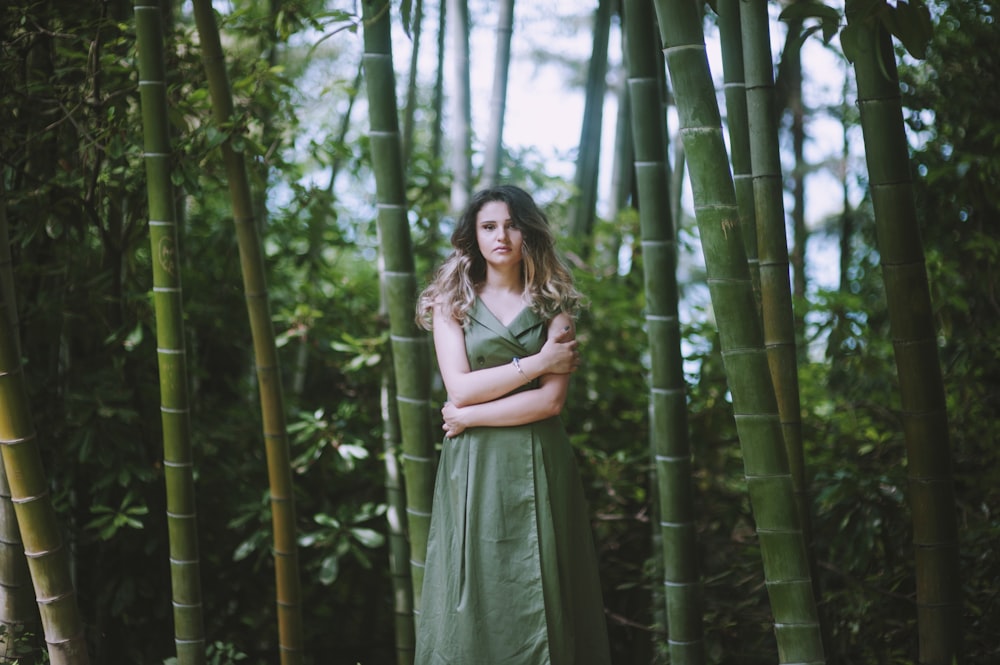 femme en robe verte près des bambous