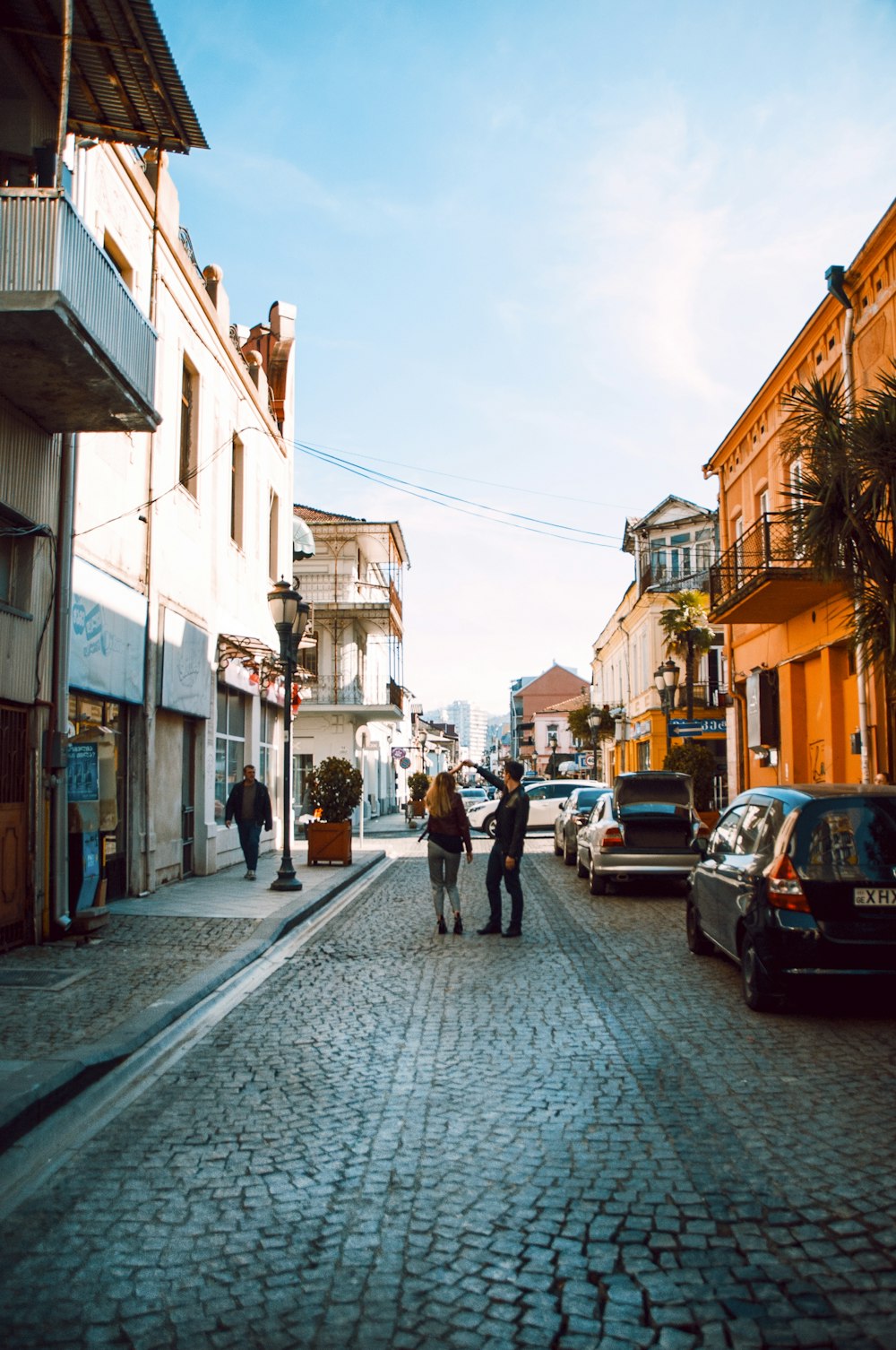 woman and man holding hands near buildings during daytime