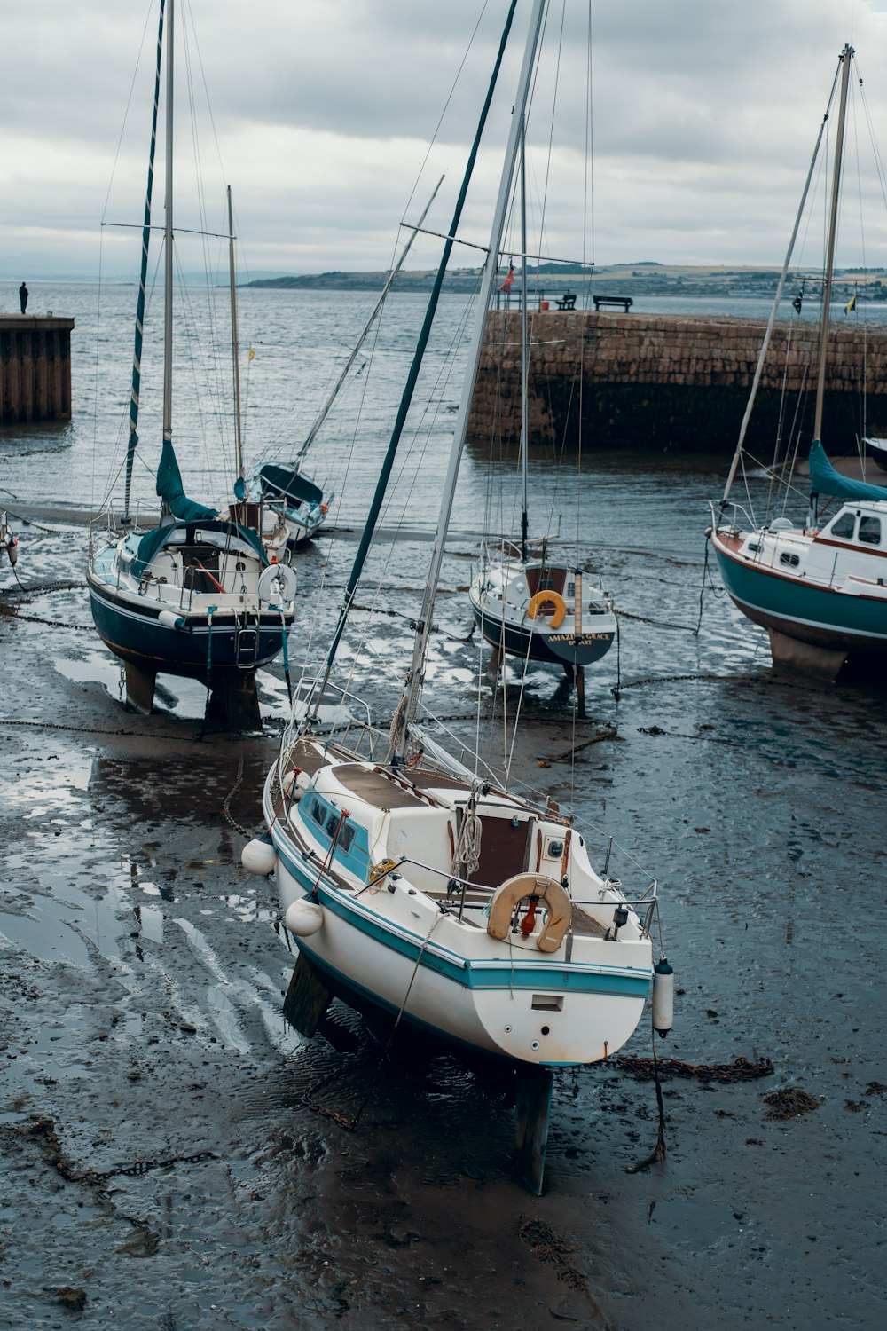four fishing boats docked on gray sandy coast during daytime