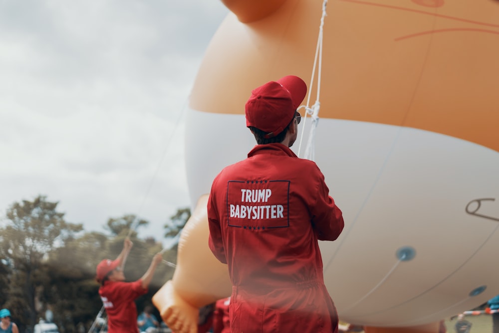 persona con gorra roja y cuerda de sujeción superior de manga larga roja